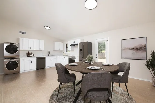 a dining room with furniture and a kitchen view