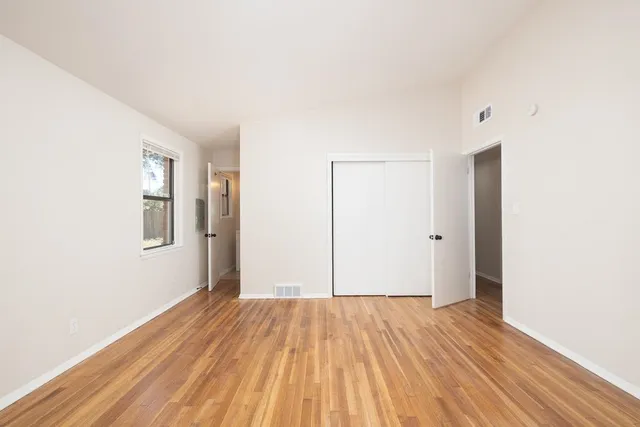 a view of a room with wooden floor and white walls