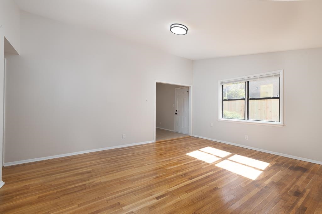 4512 Applegate Road Memphis, TN 38109 - Photo 22 of 31 a view of an empty room with wooden floor and a window