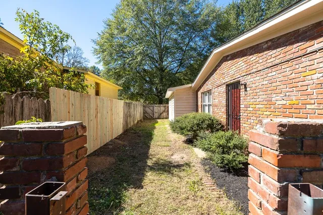 a view of a house with backyard and sitting area