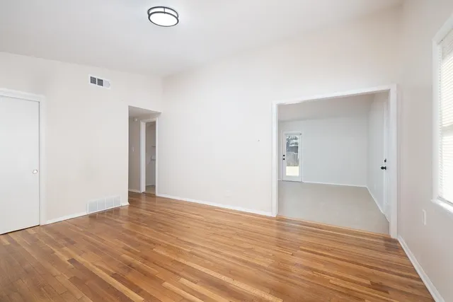 a view of an empty room with wooden floor