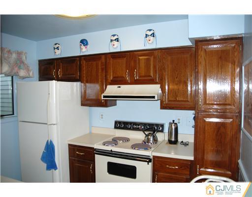 744 A Pompton Road Monroe Township, NJ 08831 - Photo 8 of 16 a kitchen with stainless steel appliances granite countertop a refrigerator a stove and a sink with wooden floors