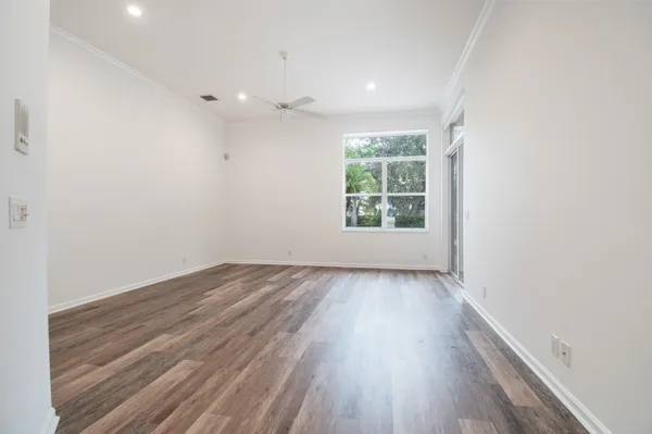 an empty room with wooden floor and windows