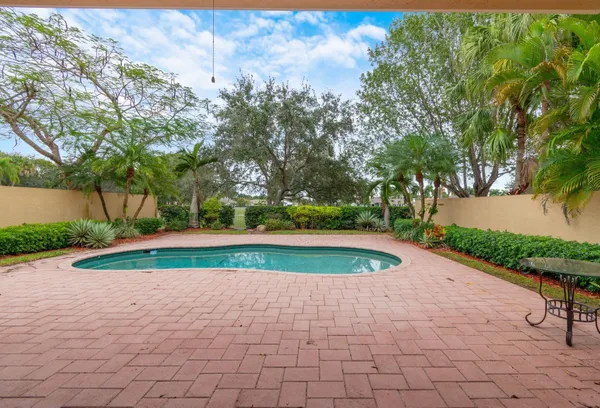 a view of backyard with swimming pool and green space