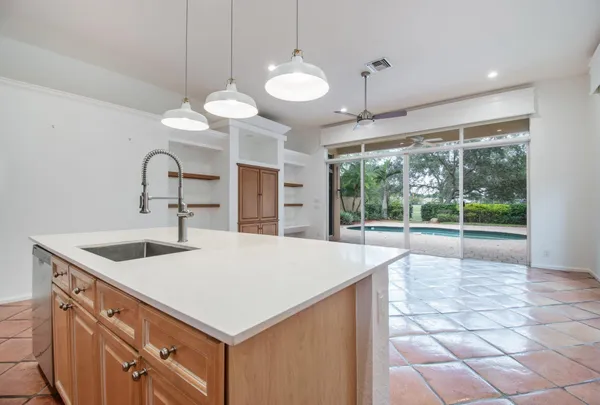 a kitchen with a sink a large window and a chandelier