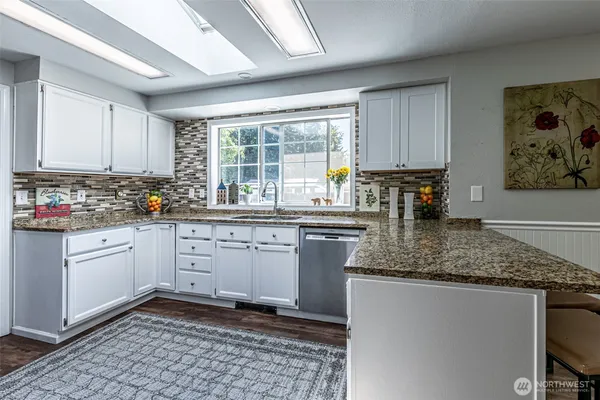 a kitchen with stainless steel appliances granite countertop a sink stove and cabinets