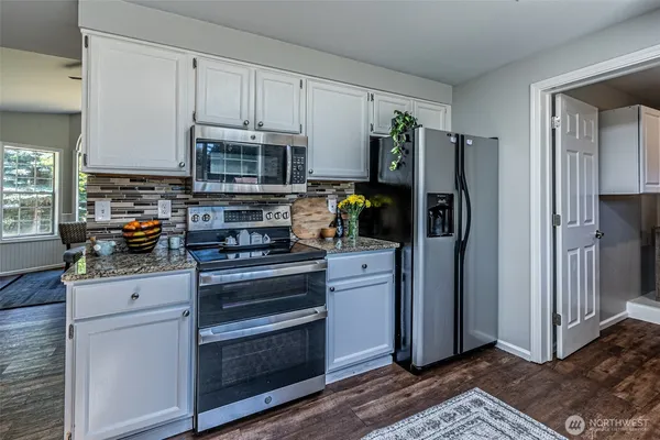 a kitchen with stainless steel appliances granite countertop a refrigerator stove and sink