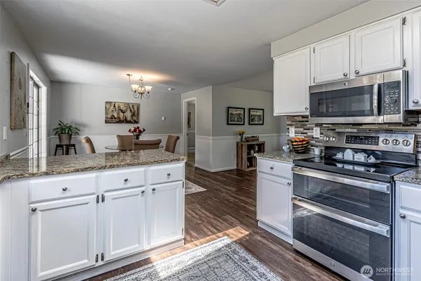 a kitchen with granite countertop cabinets stainless steel appliances and a counter space