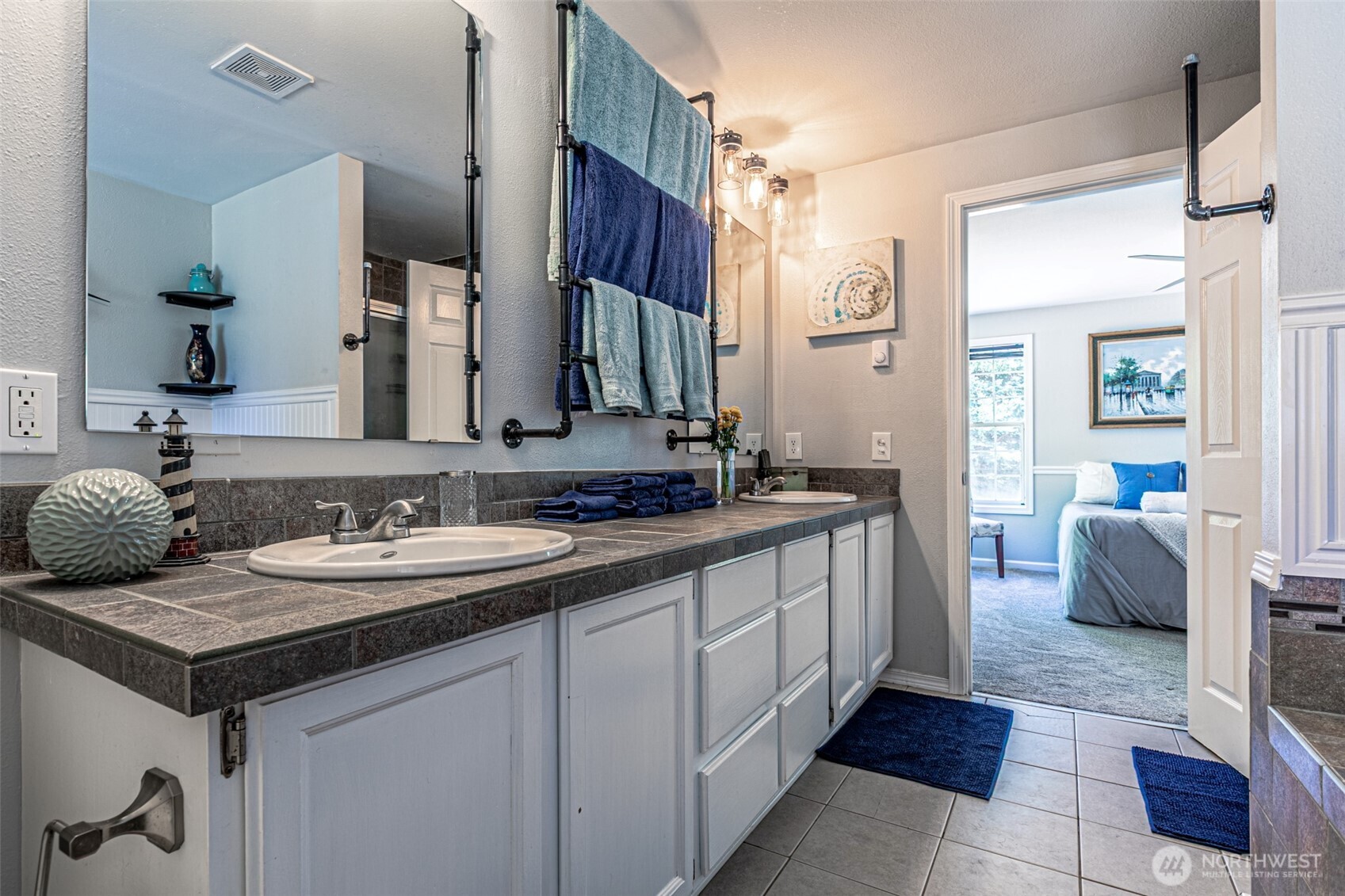 18920 217th Avenue East Orting, WA 98360 - Photo 19 of 36 a spacious bathroom with a double vanity sink a mirror and a shower