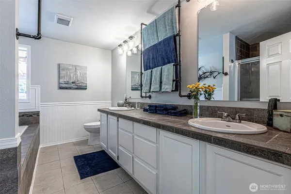 a spacious bathroom with a double vanity sink mirror and toilet