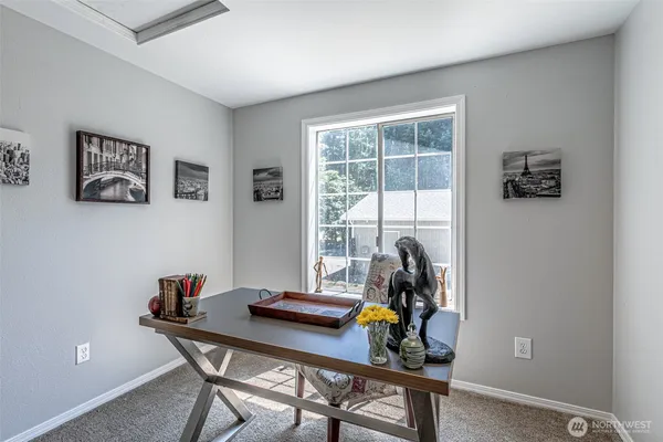 a view of a workspace with furniture and a window