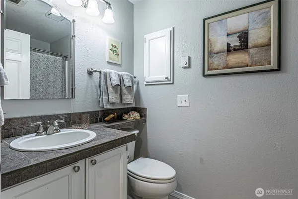 a bathroom with a toilet sink and mirror