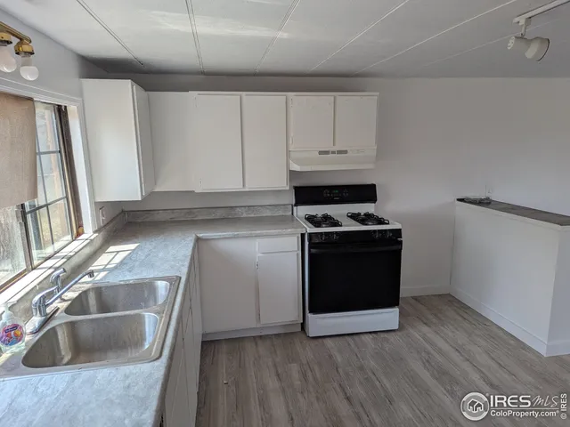 a kitchen with granite countertop a sink and a stove top oven
