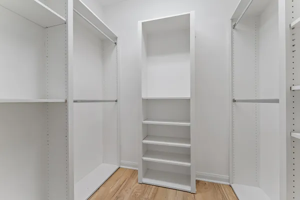 a view of walk in closet with empty racks
