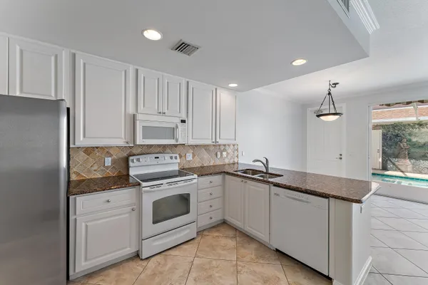 a kitchen with white cabinets stainless steel appliances and sink