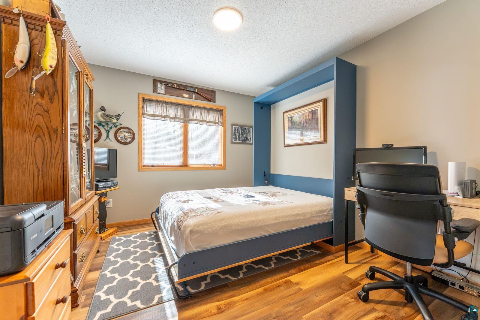 4452 Moccasin Point Road Tower, MN 55790 - Photo 20 of 44 Wood-finish flooring throughout, featuring a built-in blue wall bed system and a desk area