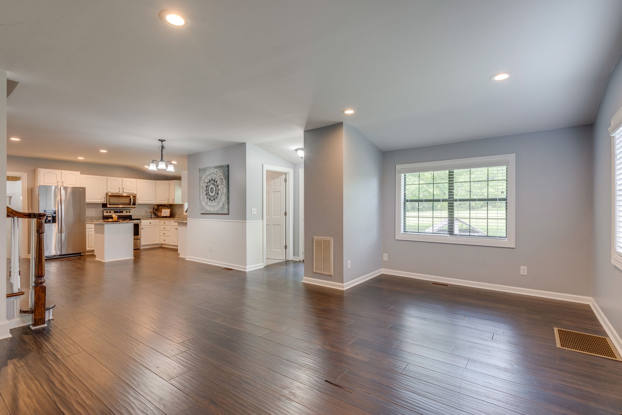6201 Ladd Road Franklin, TN 37067 - Photo 13 of 28 a view of an empty room with wooden floor and a kitchen
