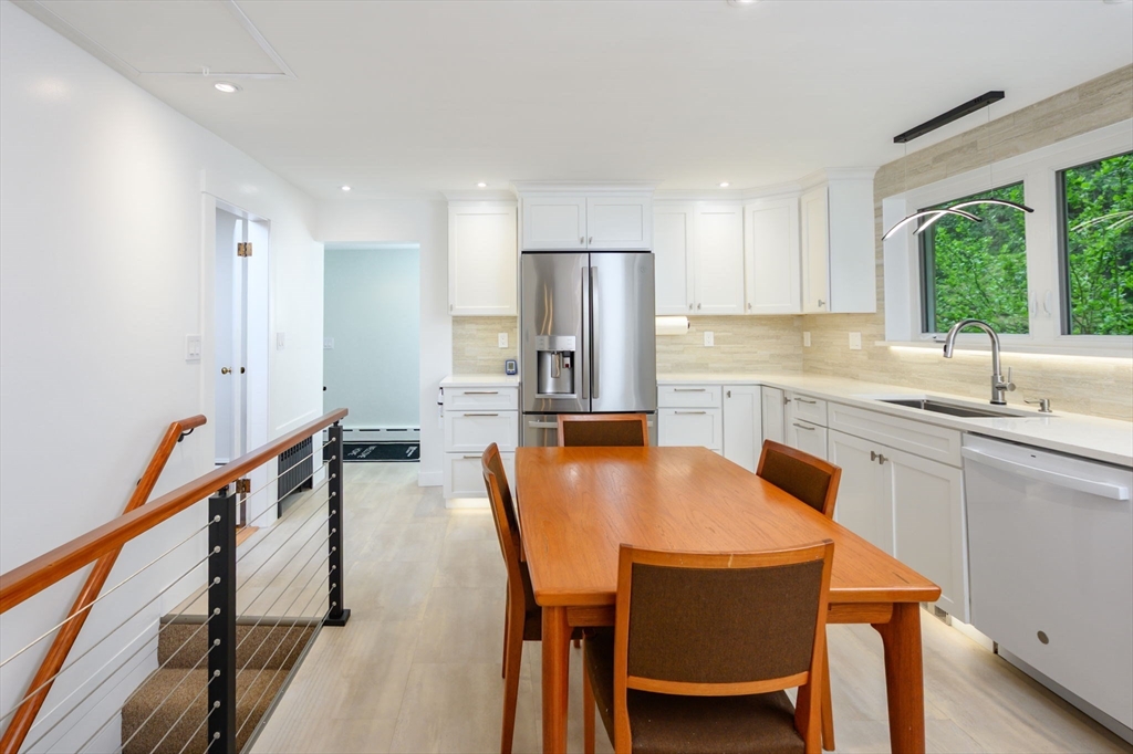 13 Smith Road Hingham, MA 02043 - Photo 3 of 32 a kitchen with stainless steel appliances granite countertop a table chairs sink and window