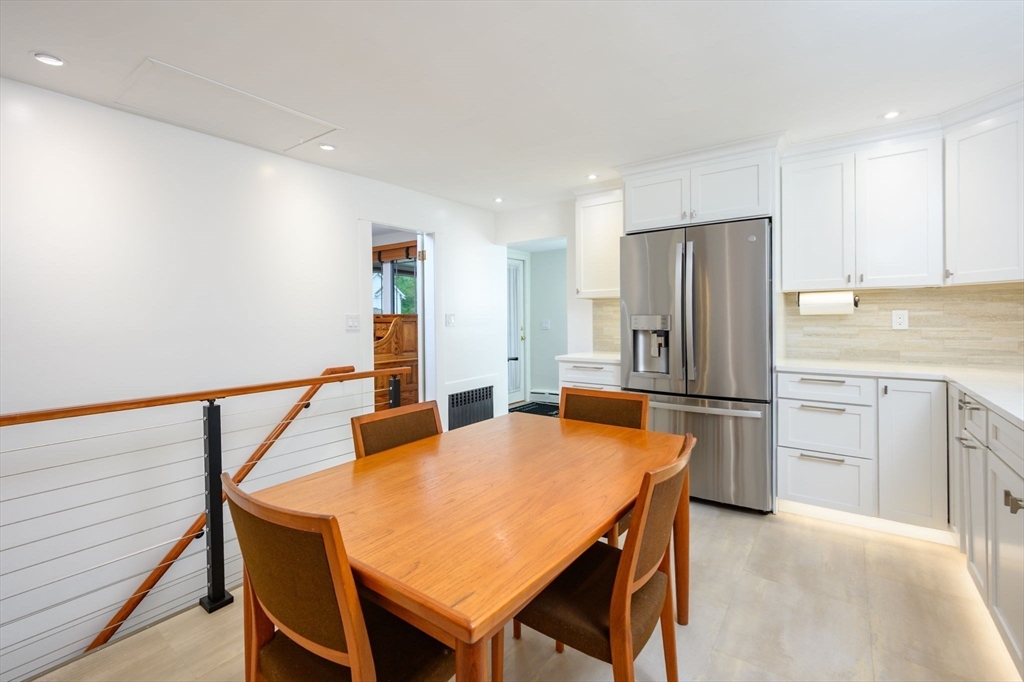 13 Smith Road Hingham, MA 02043 - Photo 4 of 32 a kitchen with stainless steel appliances a refrigerator a stove a dining table and chairs with wooden floor