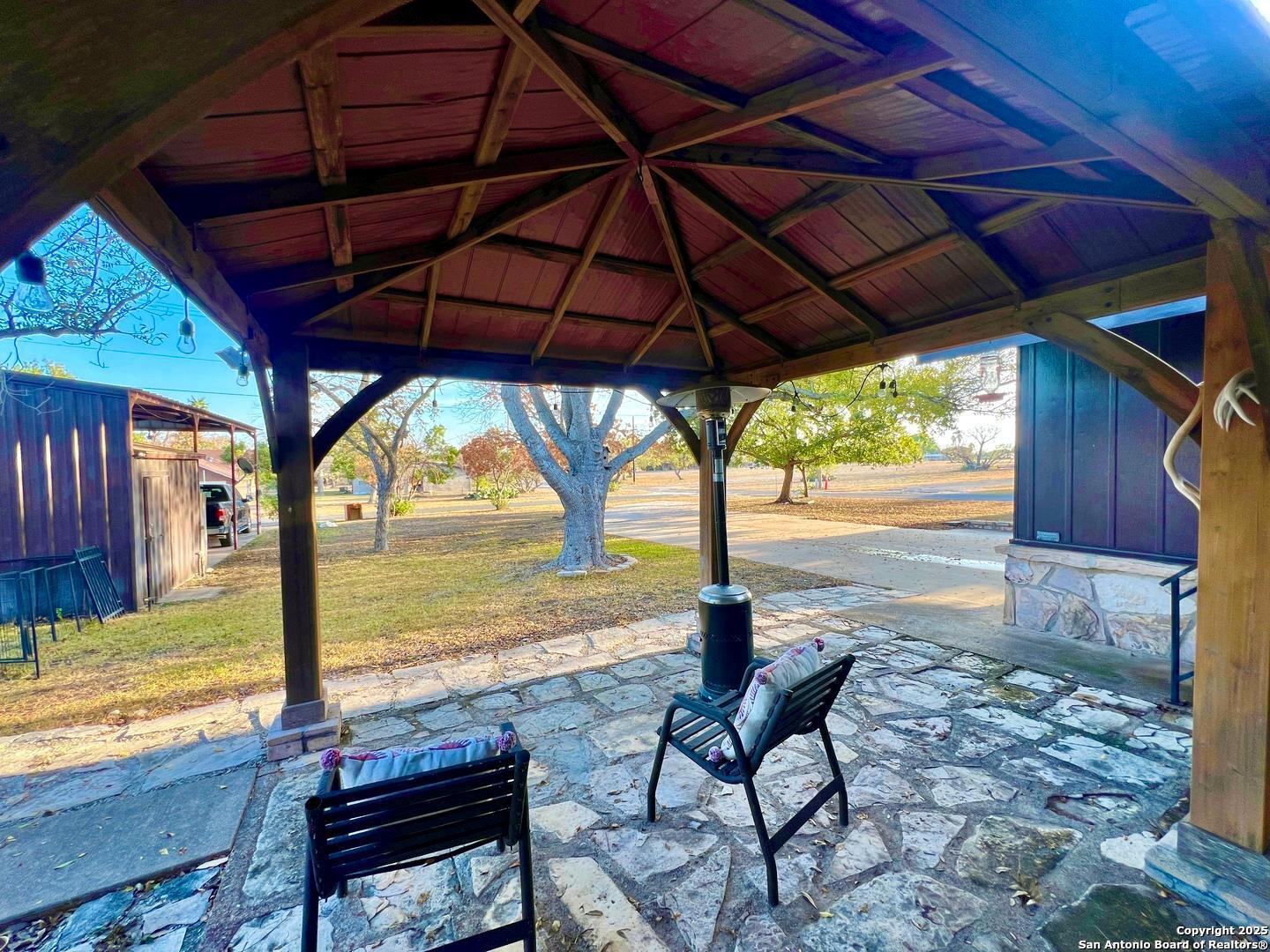 433 Fort Clark Road Brackettville, TX 78832 - Photo 25 of 46 a patio with water view with a table and chairs under an umbrella