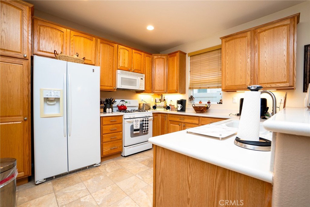 1165 Wisteria Way Beaumont, CA 92223 - Photo 15 of 49 a kitchen with a refrigerator a sink and cabinets