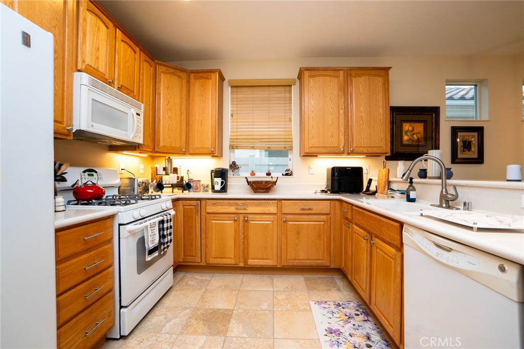 1165 Wisteria Way Beaumont, CA 92223 - Photo 16 of 49 a kitchen with stainless steel appliances granite countertop a sink and dishwasher a stove top oven with wooden floor