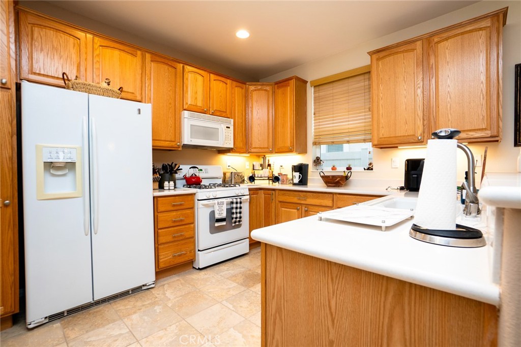 1165 Wisteria Way Beaumont, CA 92223 - Photo 19 of 49 a kitchen with granite countertop a sink appliances cabinets and a counter top space