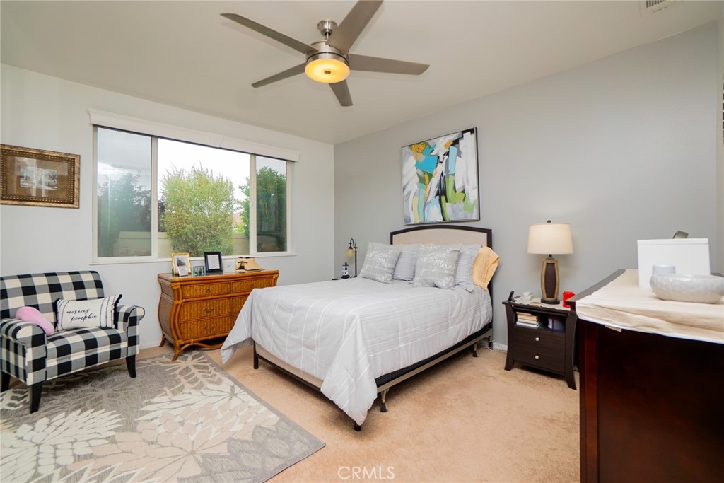 1165 Wisteria Way Beaumont, CA 92223 - Photo 23 of 49 a bedroom with a bed and a chandelier