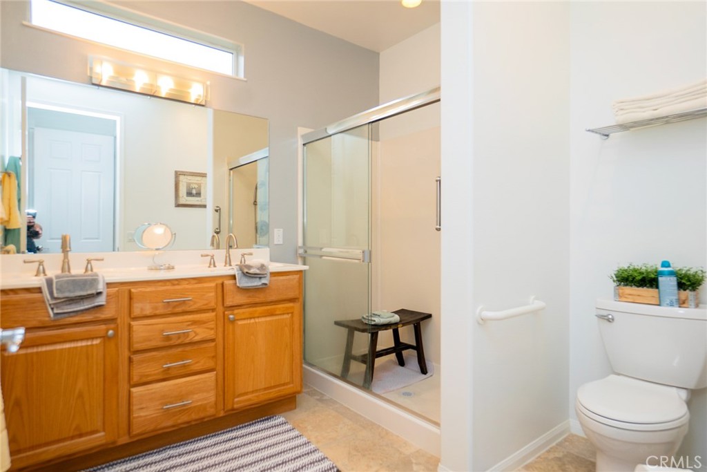 1165 Wisteria Way Beaumont, CA 92223 - Photo 32 of 49 a spacious bathroom with a granite countertop sink a toilet a mirror a vanity and shower
