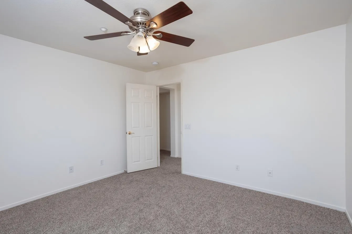 2168 Pointe Parkway Spring Valley, CA 91978 - Photo 26 of 50 an empty room with a chandelier fan and windows
