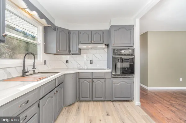 a kitchen with a sink cabinets stainless steel appliances and a window