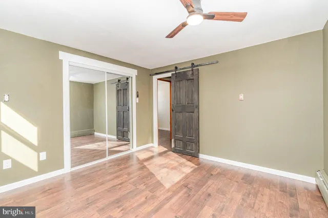 a view of an empty room with closet and a window
