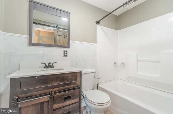 a bathroom with a granite countertop bathtub shower and toilet