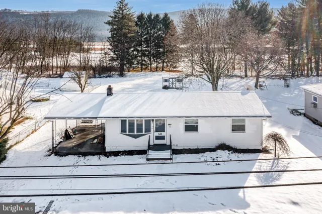 a view of a white house with a snow on the road