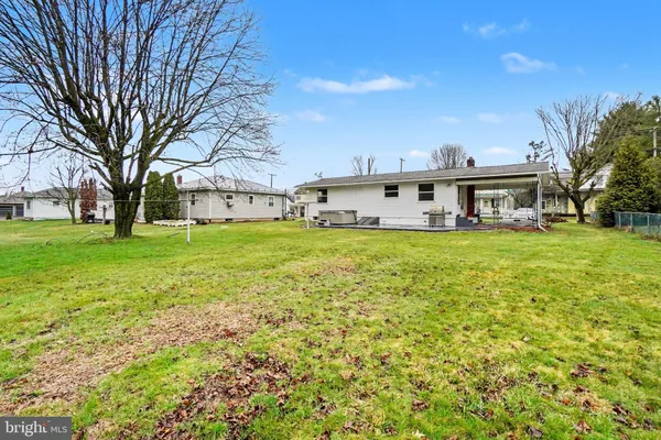 a view of a house with a big yard and large trees