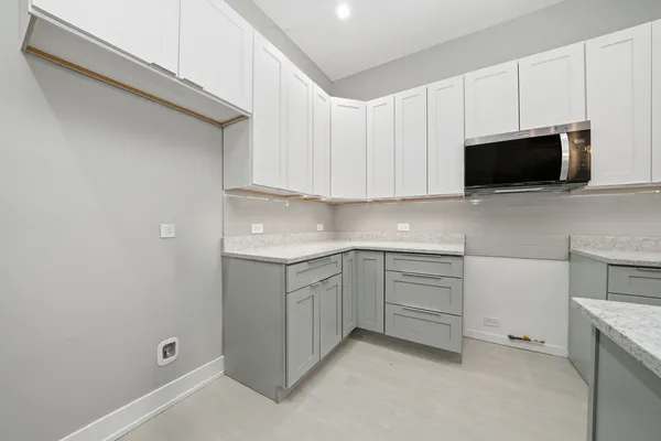a kitchen that has a sink a stove and a wooden floor
