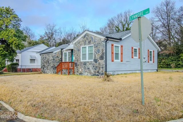 a front view of house with yard and trees in the background