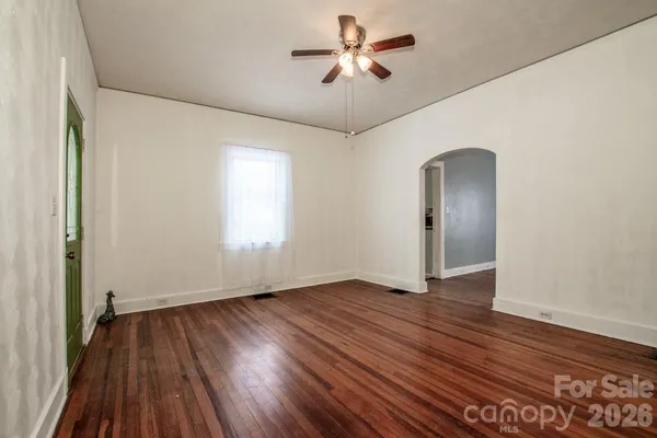 a view of an empty room with wooden floor