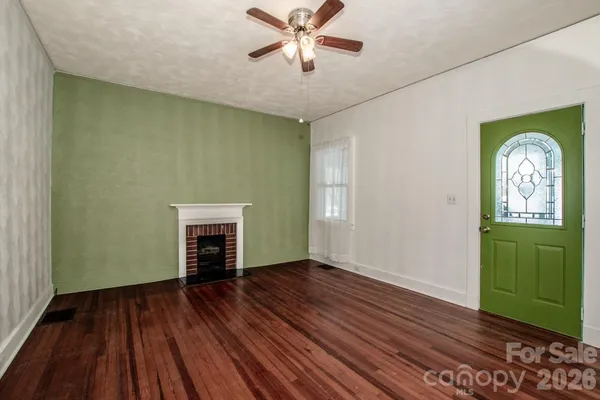 a view of an empty room with window and wooden floor