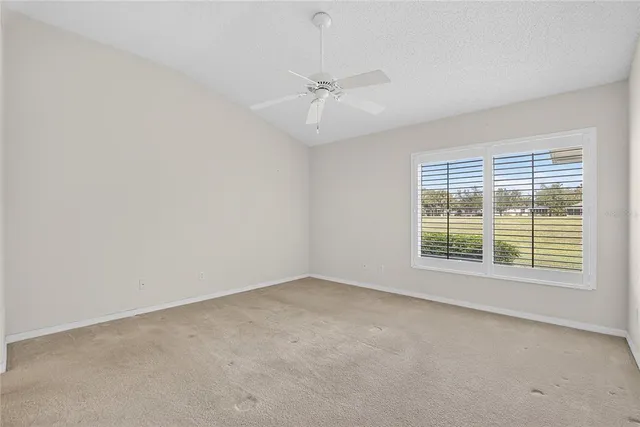 an empty room with a window and a fan