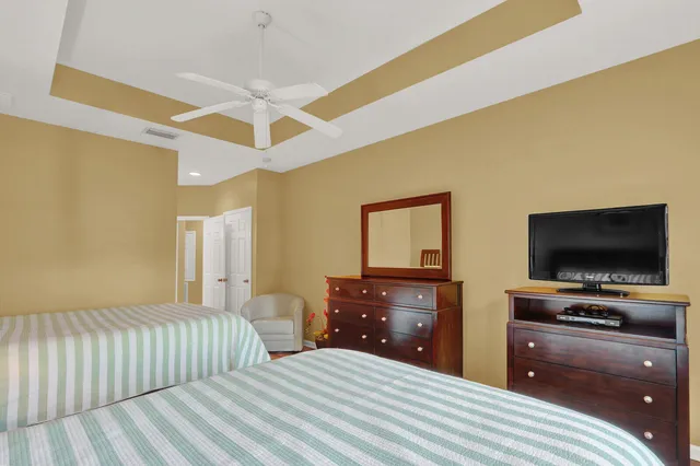 a bedroom with a bed and a flat tv screen on dresser