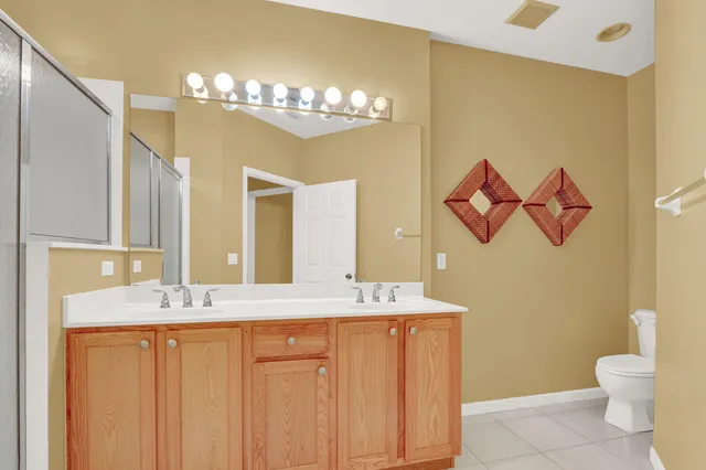 a bathroom with a granite countertop sink a toilet and a mirror