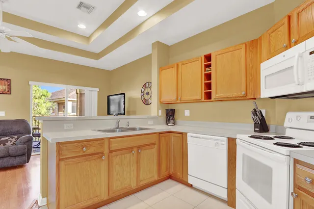 a kitchen with cabinets appliances a sink and a window