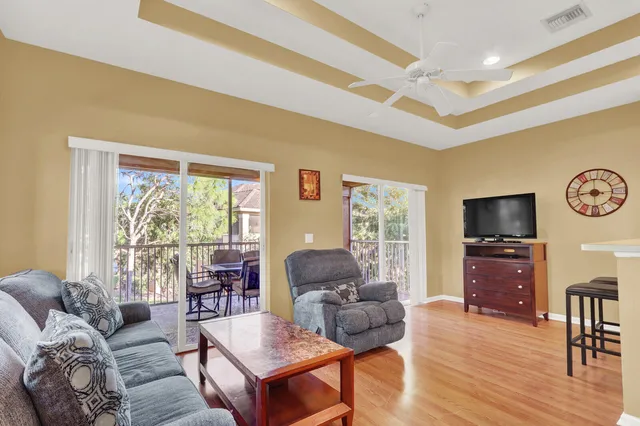 a living room with furniture a flat screen tv and wooden floor