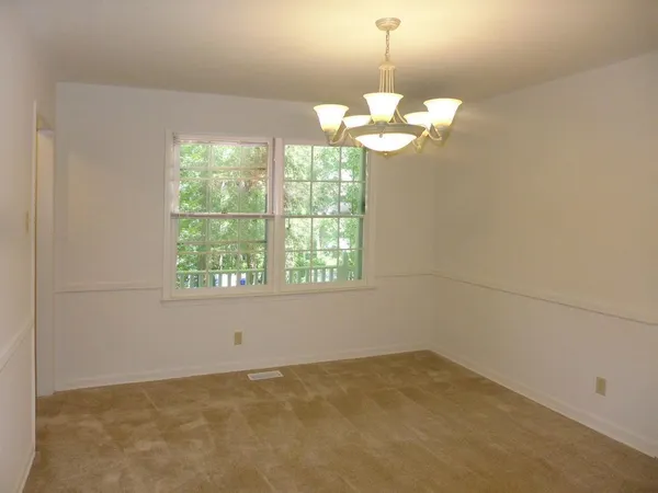 a view of a room with a chandelier fan and windows