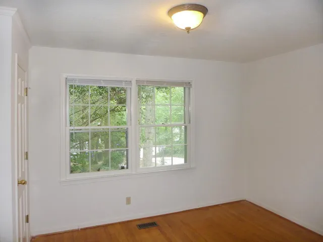 a view of a room with wooden floor and windows