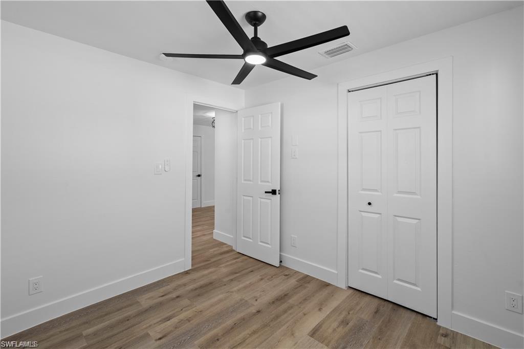 1855 Danford Street, Unit A Naples, FL 34112 - Photo 20 of 22 Unfurnished bedroom featuring light wood-type flooring, a ceiling fan, and a closet