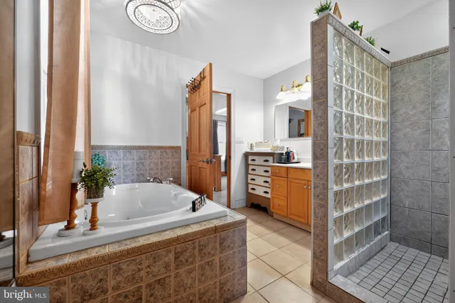 a bathroom with a tub sink and mirror