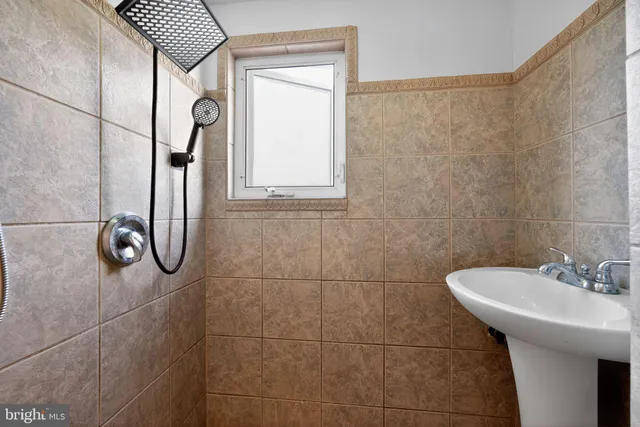 a bathroom with a sink a shower and a mirror