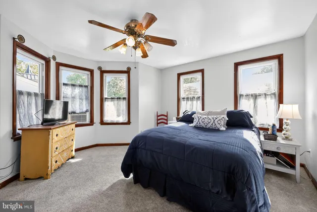 a bedroom with a bed a dresser next to a window